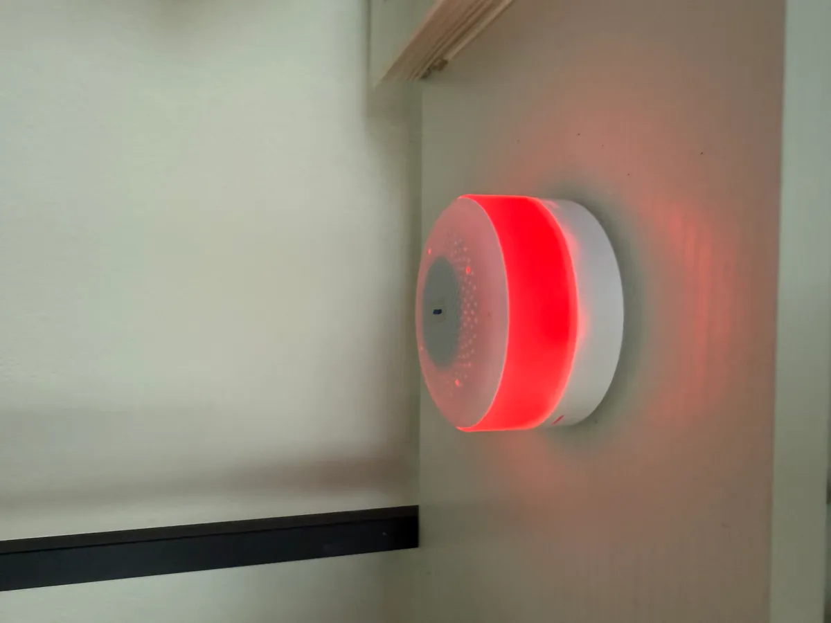 SeniorMatics sensor — a small white device with a soft LED ring, mounted discreetly on a wall