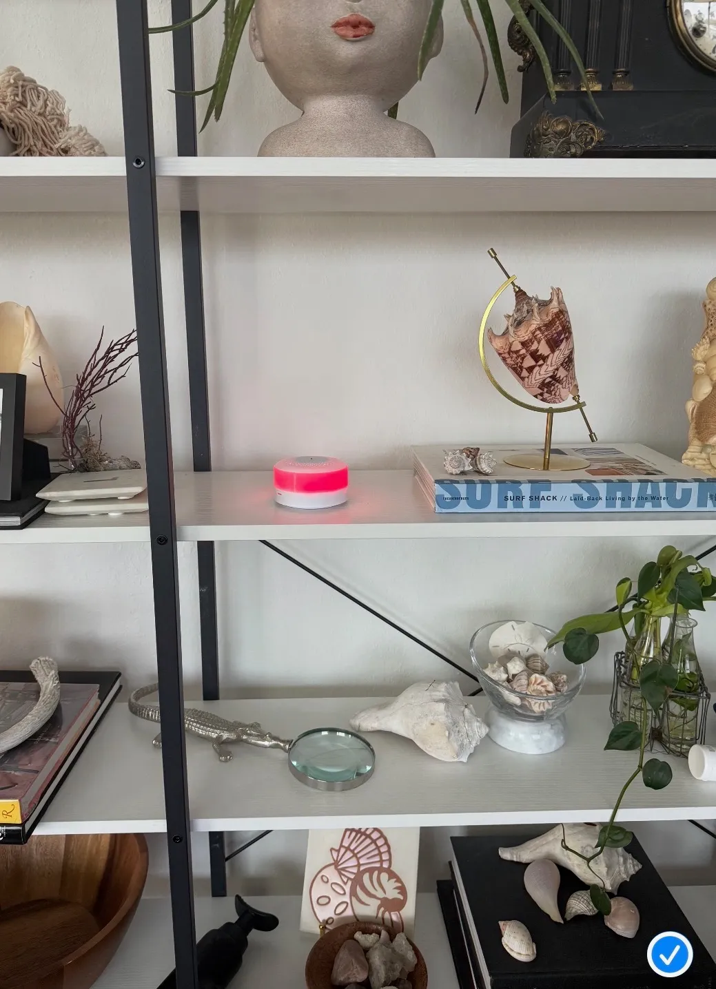 SeniorMatics sensor — a small white device with a soft LED ring, placed discreetly on a shelf in a living room